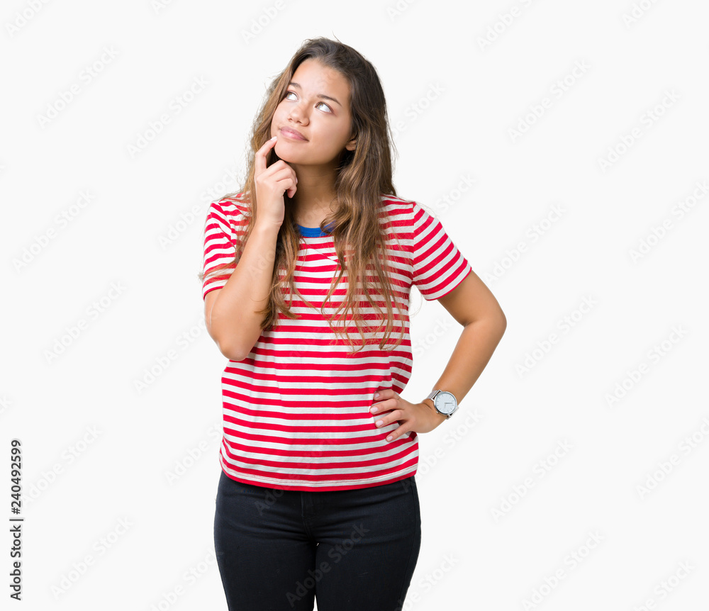 Young beautiful brunette woman wearing stripes t-shirt over isolated background with hand on chin thinking about question, pensive expression. Smiling with thoughtful face. Doubt concept. Young beautiful brunette woman wearing stripes t-shirt over isolated background with hand on chin thinking about question, pensive expression. Smiling with thoughtful face. Doubt concept.