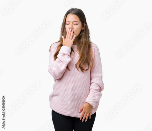 Young beautiful brunette woman wearing pink winter sweater over isolated background bored yawning tired covering mouth with hand. Restless and sleepiness.