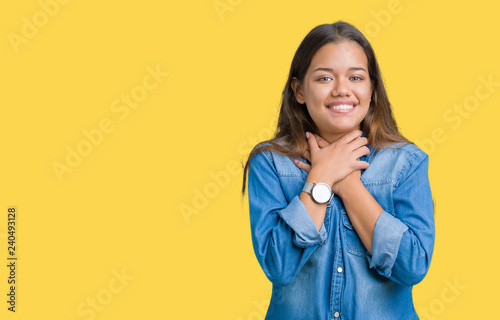 Young beautiful brunette woman wearing blue denim shirt over isolated background shouting and suffocate because painful strangle. Health problem. Asphyxiate and suicide concept.
