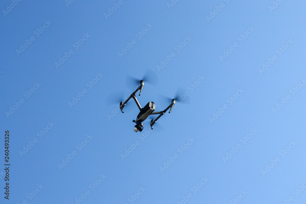Drone with video camera against the sky.