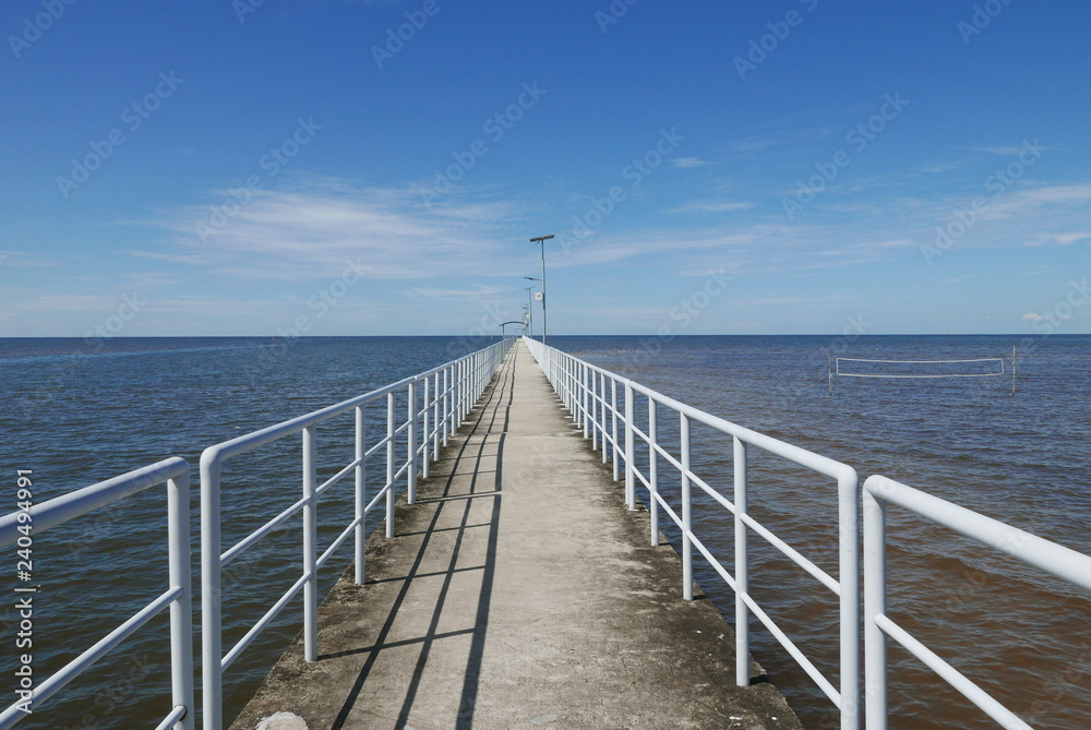Perspective view of jetty with LED street light with solar cell on clear blue sky.