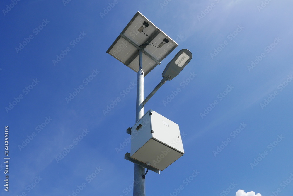 Close up view of LED street light with solar cell on clear blue sky background with clouds.