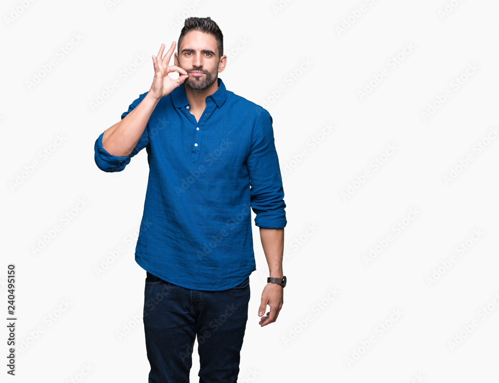 Young handsome man over isolated background mouth and lips shut as zip with fingers. Secret and silent, taboo talking Young handsome man over isolated background mouth and lips shut as zip with fingers. Secret and silent, taboo talking