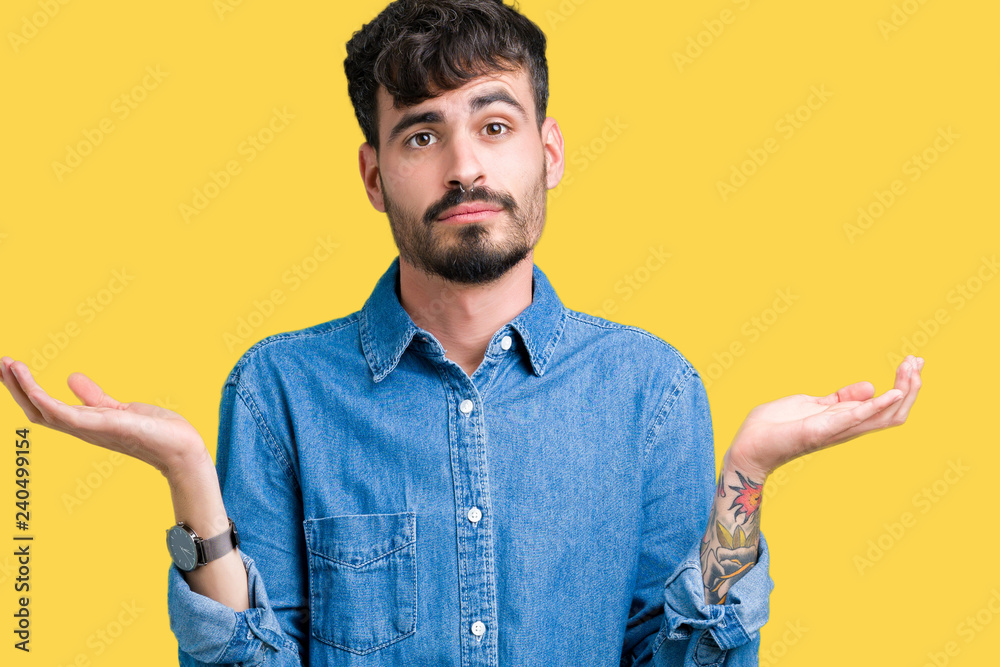 Young handsome man over isolated background clueless and confused expression with arms and hands raised. Doubt concept. Young handsome man over isolated background clueless and confused expression with arms and hands raised. Doubt concept.
