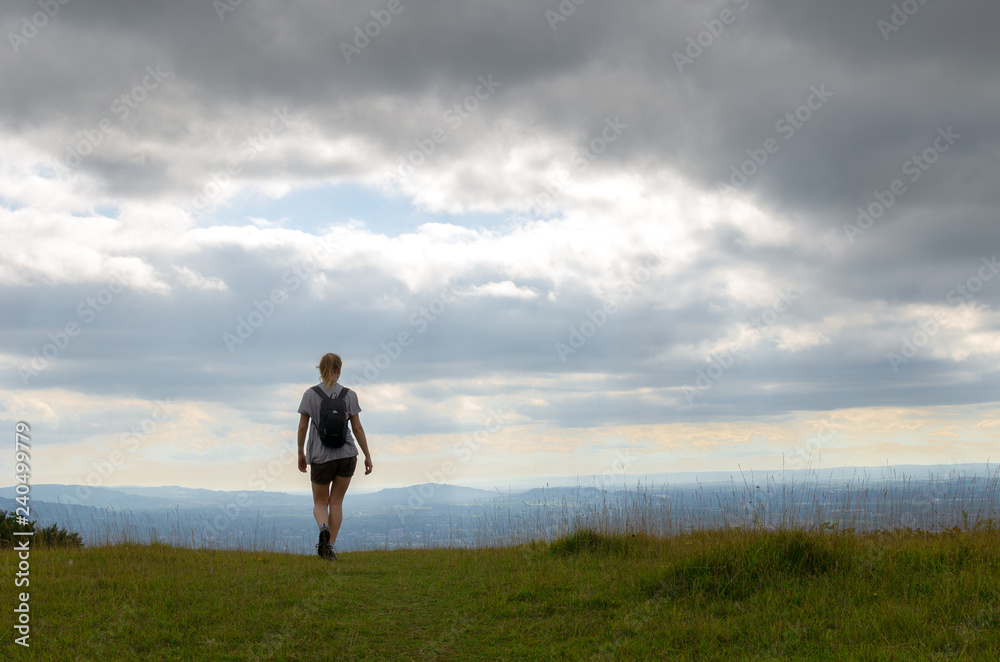 Woman walking in the countryside. Photo taken in the Cotswold Way, Gloucestershire, England Woman walking in the countryside. Photo taken in the Cotswold Way, Gloucestershire, England