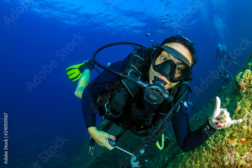Female SCUBA diver on a colorful, tropical coral reef