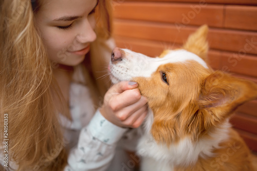 portrair of smiling girl cuddle red and white dog border collie
