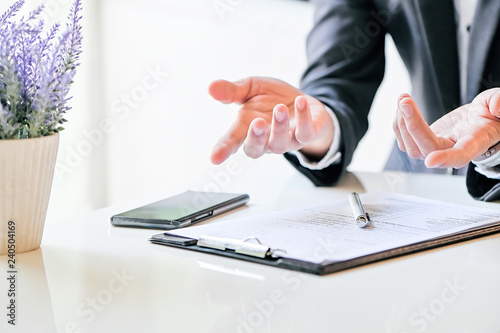 Shot of businessman hand pointing forward while sitting at white table photo