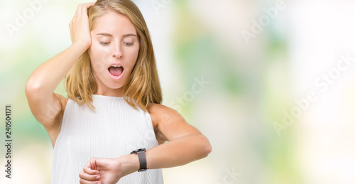 Beautiful young elegant woman over isolated background Looking at the watch time worried, afraid of getting late