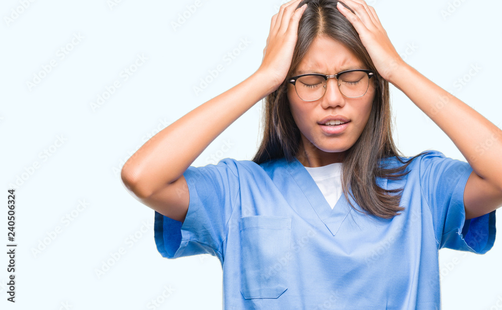 Young asian doctor woman over isolated background suffering from headache desperate and stressed because pain and migraine. Hands on head. Young asian doctor woman over isolated background suffering from headache desperate and stressed because pain and migraine. Hands on head.