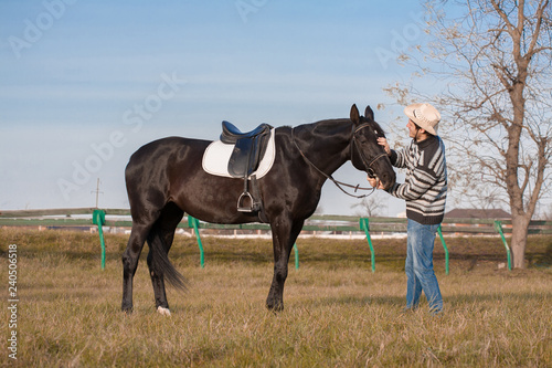 Man nearby horse  striped pullover  blue jeans  hat  landscape