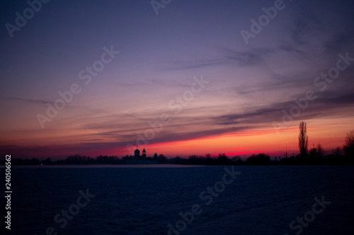 Colorful sunset. On the horizon you can see the silhouette of buildings