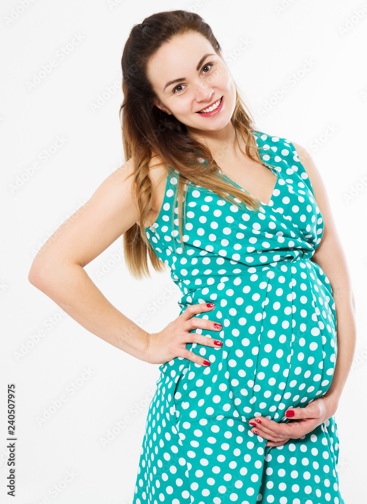 Pregnant woman in dress holds hands on belly isolated on white background. Pregnancy and maternity concept. Mother day. Copy space.