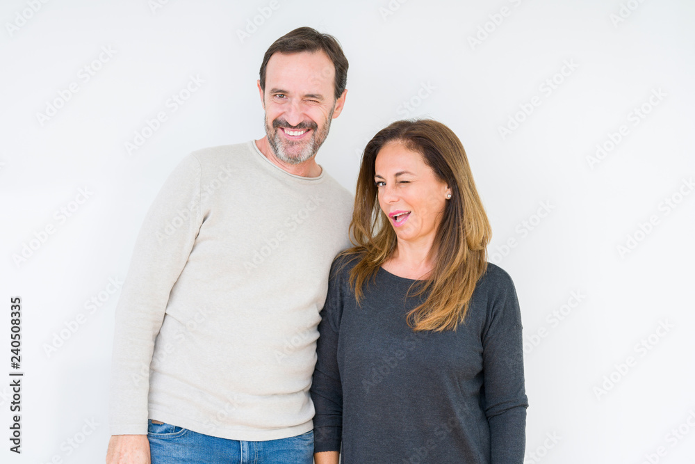 Beautiful middle age couple in love over isolated background winking looking at the camera with sexy expression, cheerful and happy face. Beautiful middle age couple in love over isolated background winking looking at the camera with sexy expression, cheerful and happy face.