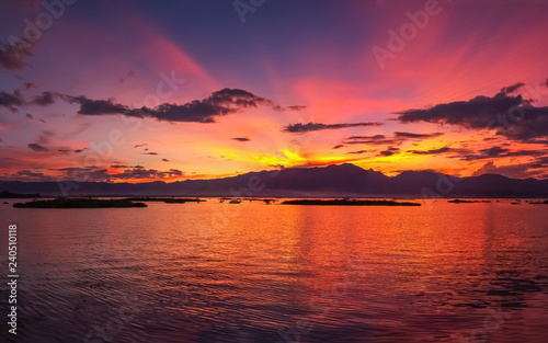 Lake view evening, view silhouette of mountain with colorful red sun light in the sky background, sunset at Kwan Phayao Lake, Phayao, northern of Thailand.