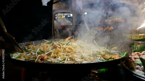 Street food thai man is cooking at night food market in island Koh Phangan, Thailand, Asie