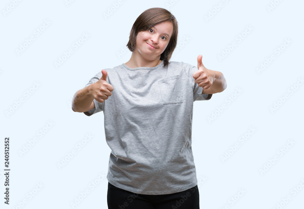 Young adult woman with down syndrome over isolated background success sign doing positive gesture with hand, thumbs up smiling and happy. Looking at the camera with cheerful expression Young adult woman with down syndrome over isolated background success sign doing positive gesture with hand, thumbs up smiling and happy. Looking at the camera with cheerful expression