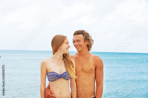 Portrait of young couple in love at beach and enjoying time being together. Young couple having fun on a sandy coast. © Georgii