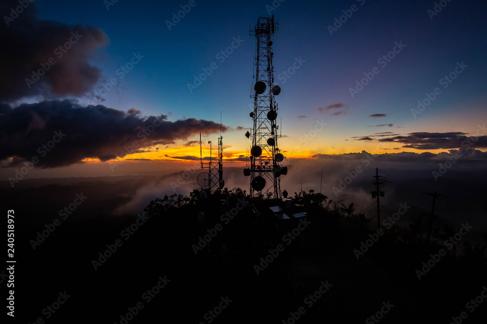 Telecommunication transmitting tower at dawn on top