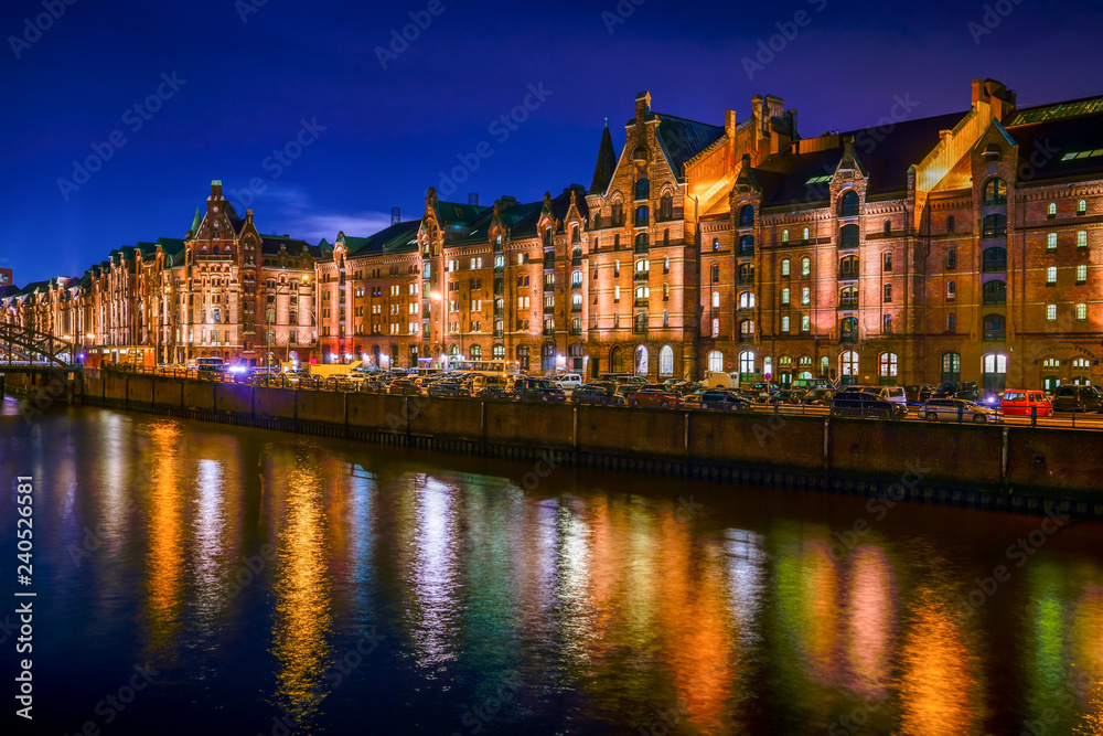 The Warehouse District (Speicherstadt) in Hamburg, Germany, at night. The panoramic view is across the inner harbor (Binnenhafen) with the bridge 