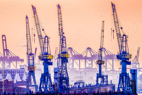 Cranes in Hamburg Harbor, Germany, seen against the late evening sky. photo