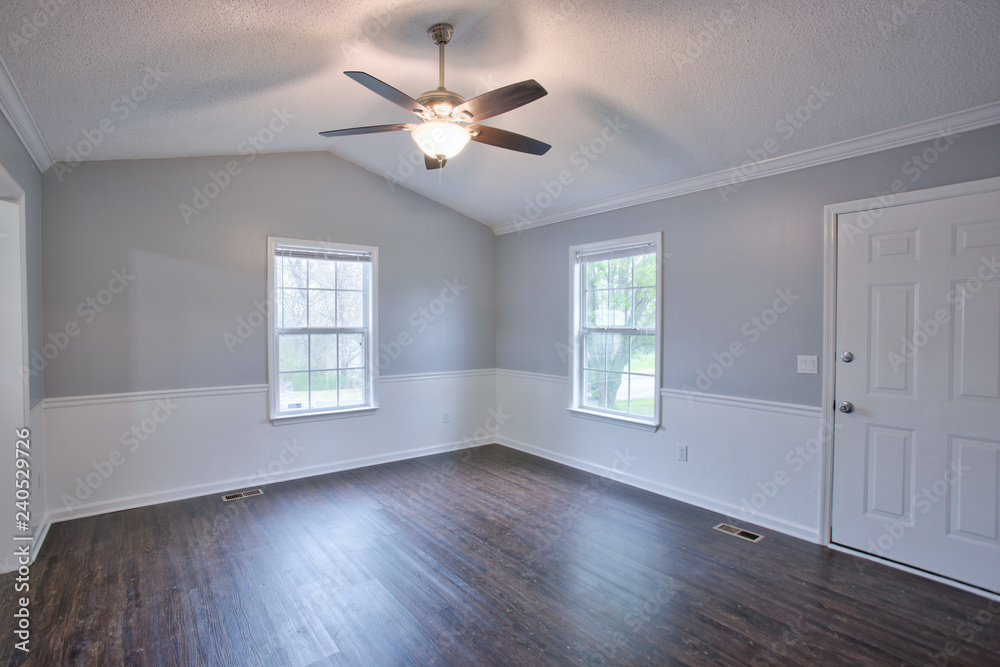 Gray living room interior with vaulted ceilings and chair rail. Stock