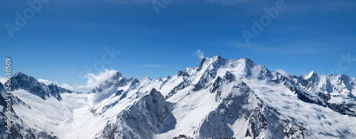 Panorama of snow-capped mountain peaks and beautiful blue sky © BSANI