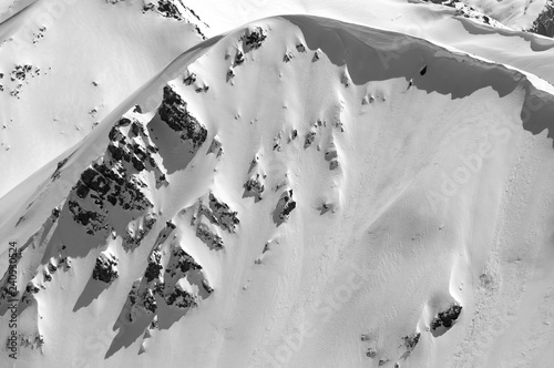 Snow cornice in winter mountains in cold sunny day photo