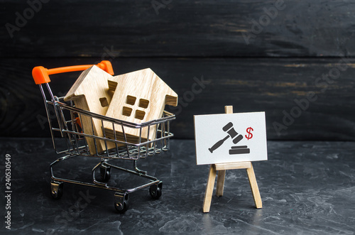 Wooden houses in a supermarket cart. uction for the purchase of housing and buildings. The growth of the city and its population. Investments. concept of rising prices for housing or rent photo