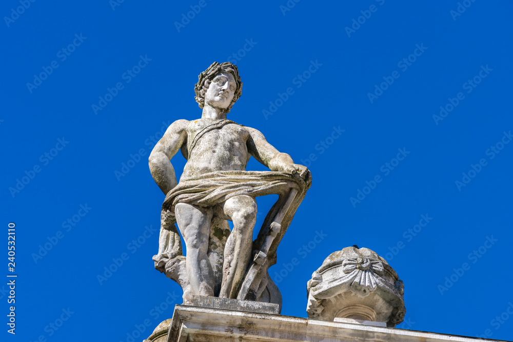 Stone statue on the roof of the Old Stock Exchange (Alte Handelsboerse) in Leipzig, Germany. Built in the 17th century in early Baroque style, it served as a prestigious gathering-place for merchants.