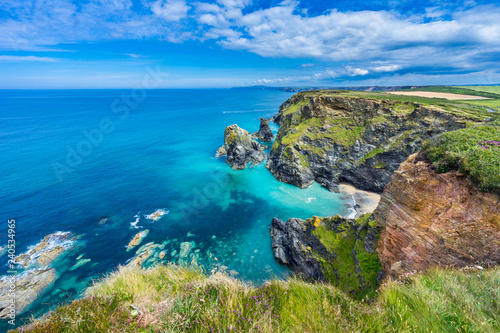 View of the South Devon coast, England, in the summer with clear waters, blue sky and grass. photo