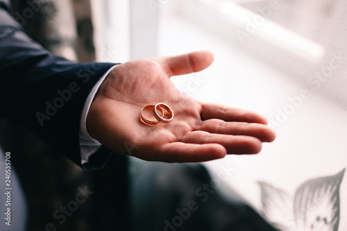 wedding rings in hands of newlyweds