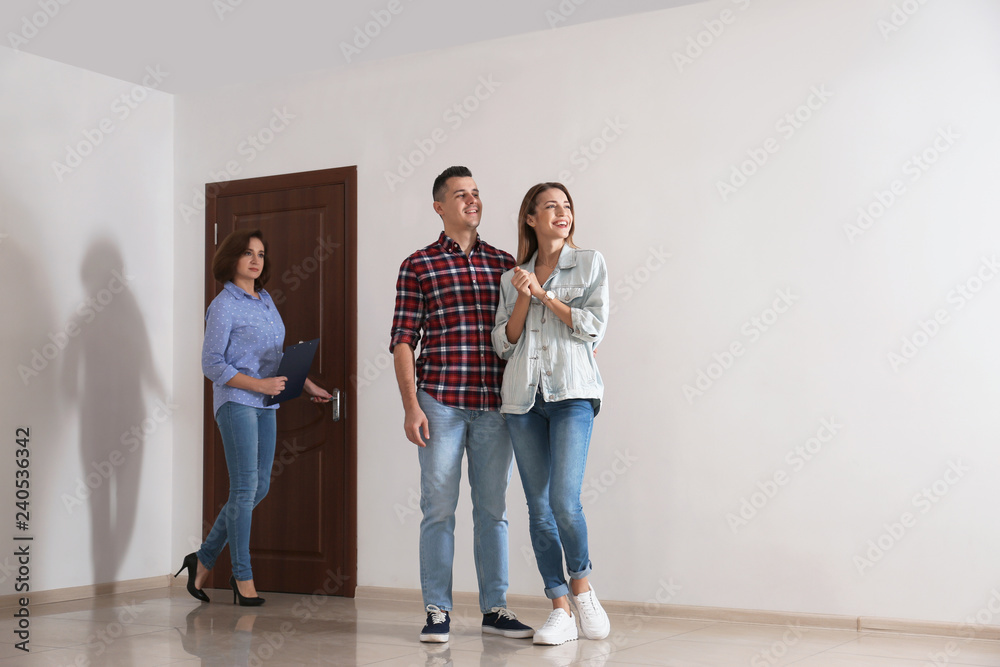 Real estate agent showing new apartment to young couple. Space for text Real estate agent showing new apartment to young couple. Space for text