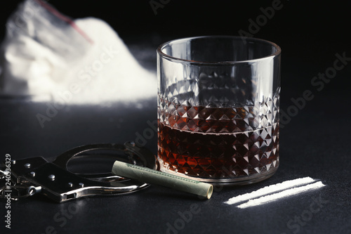 Fényképezés Glass of alcohol, cocaine, money and handcuffs on dark table