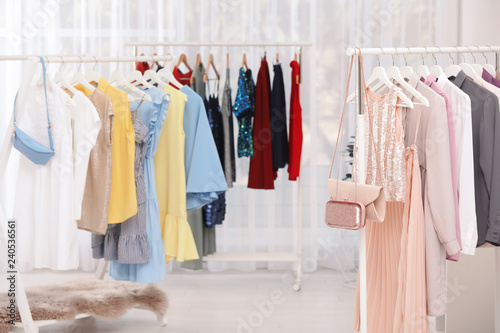 Racks with stylish clothes in light room