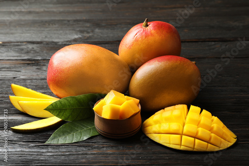 Composition with fresh mango on wooden background
