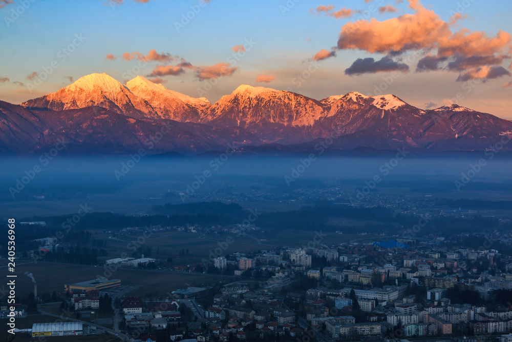 Kamnik-Savinja Alps rising above the city of Kranj at the sunset