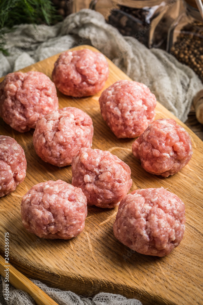 Raw meatballs on the wooden cutting board. Raw meatballs on the wooden cutting board.