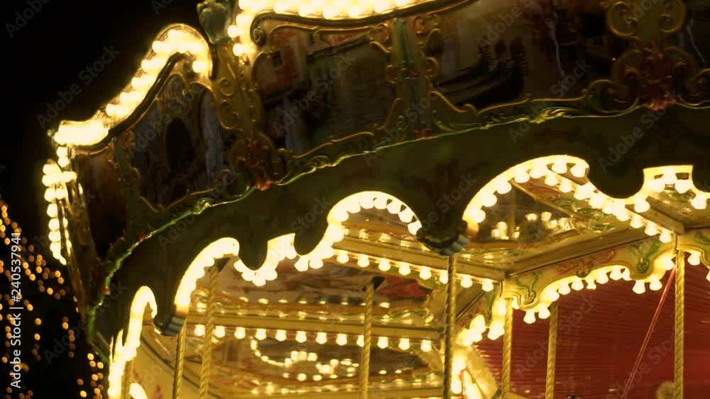 Fascinating flashing lights dark night sky illumination of vintage merry go round fair carousel ferris wheel at carnival