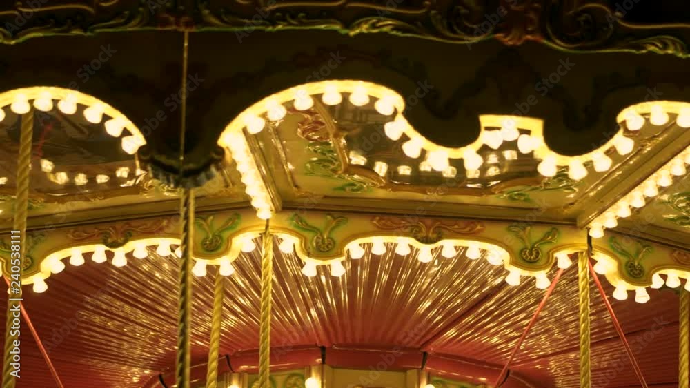 Fascinating flashing lights dark night sky illumination of vintage merry go round fair carousel ferris wheel at carnival