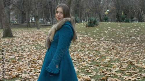 eductive Woman In a Blue Coat Walking In The Park