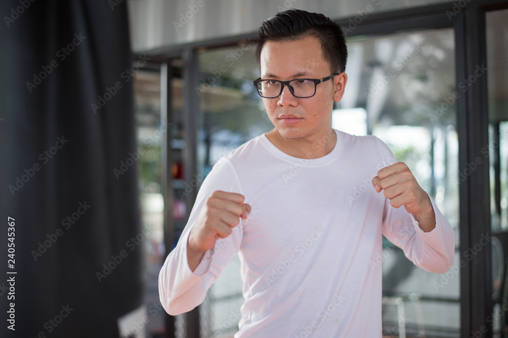 Fototapeta premium sportsman practicing boxing in gym. he punch the punching bag.