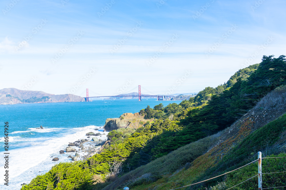 The view of golden gate bridge in Lands end at San Francisco- San Francisco. summer , cloud , rock , sea, plant.