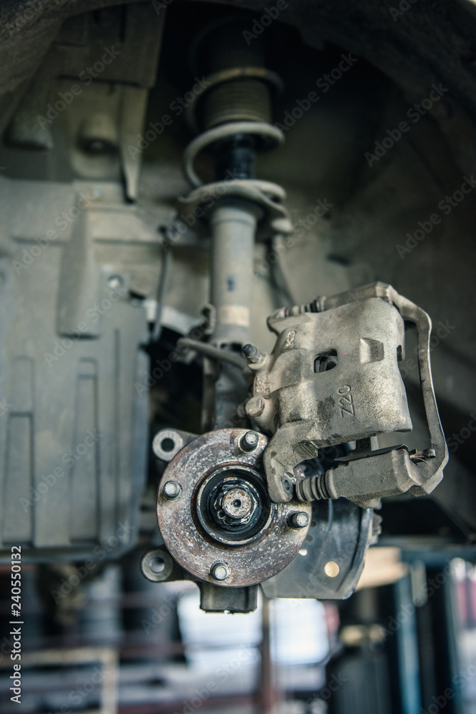 Car mechanics are replacing used brake discs. Car mechanics are replacing used brake discs.