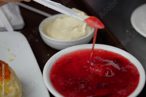 Фотография Young muslim woman sweep the strawberry jam on scone at the strawberry farm at Cameron Highland