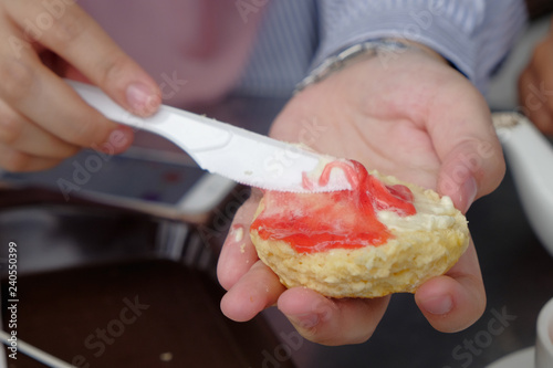 Картината върху платно Young muslim woman sweep the strawberry jam on scone at the strawberry farm at Cameron Highland