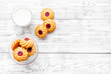Drink milk with cookies concept. Cup of milk and fresh homemade cookies on white wooden background top view space for text