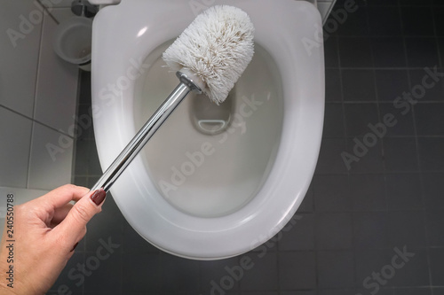 close up woman use brush for cleaning toilet bowl for health