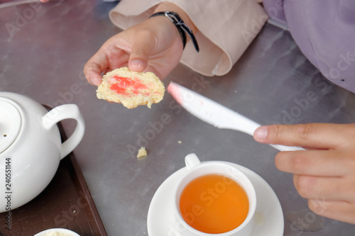 Картината върху платно Young muslim woman sweep the strawberry jam on scone at the strawberry farm at Cameron Highland