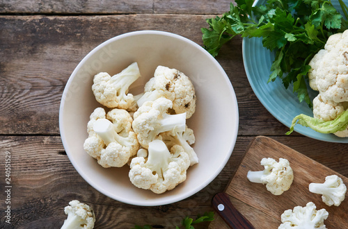 Pieces of raw cauliflower in a bowl on a wooden table